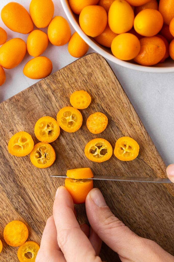 Kumquats being sliced into rounds.