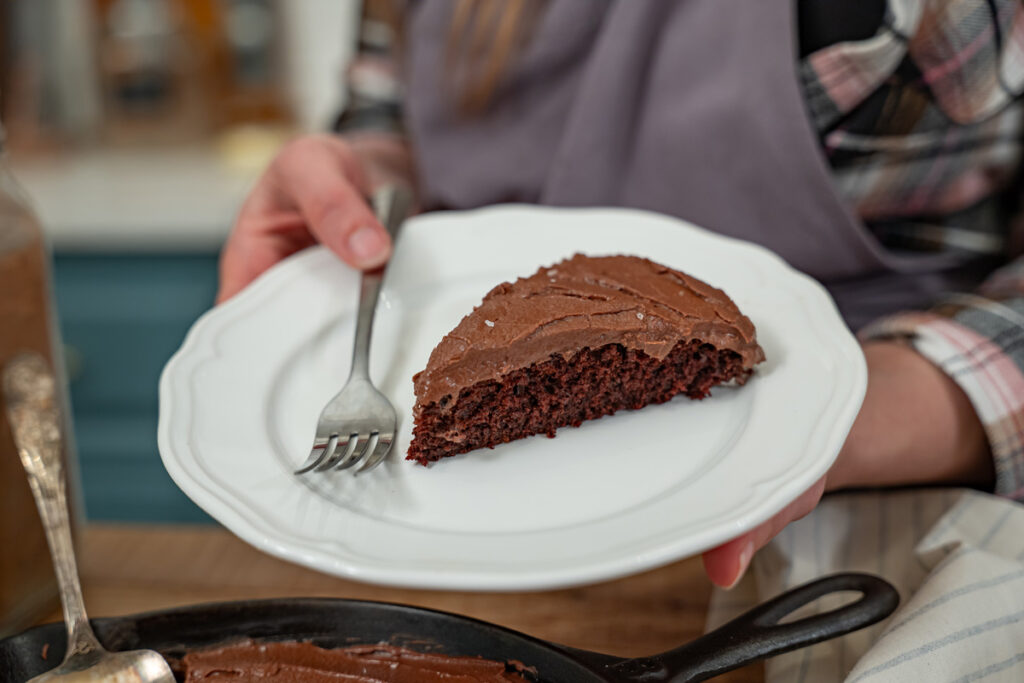 A slice of chocolate wacky cake on a white plate.