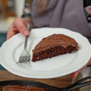 A slice of chocolate wacky cake on a white plate.