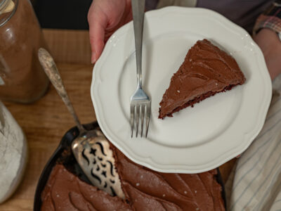 A slice of chocolate wacky cake on a white plate.