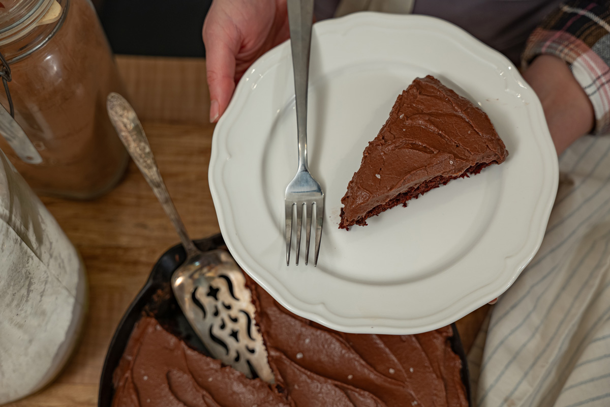 A slice of chocolate wacky cake on a white plate.