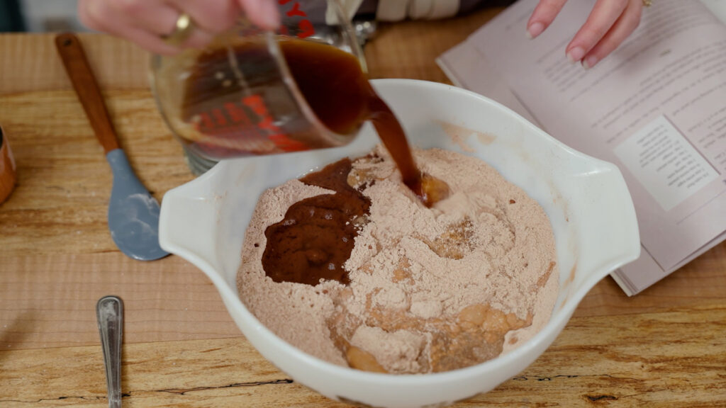 Chocolate wacky cake batter being mixed in a bowl.