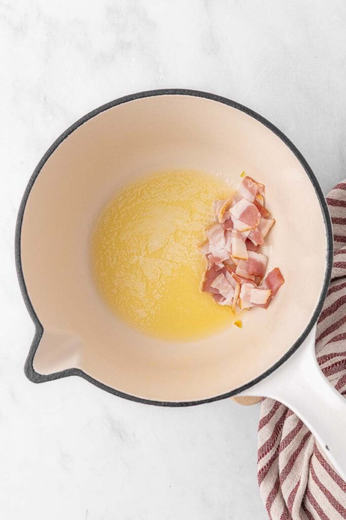 Melted butter with bacon cooking in a large soup pot.