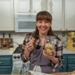 A woman holding a jar of homemade crackers.