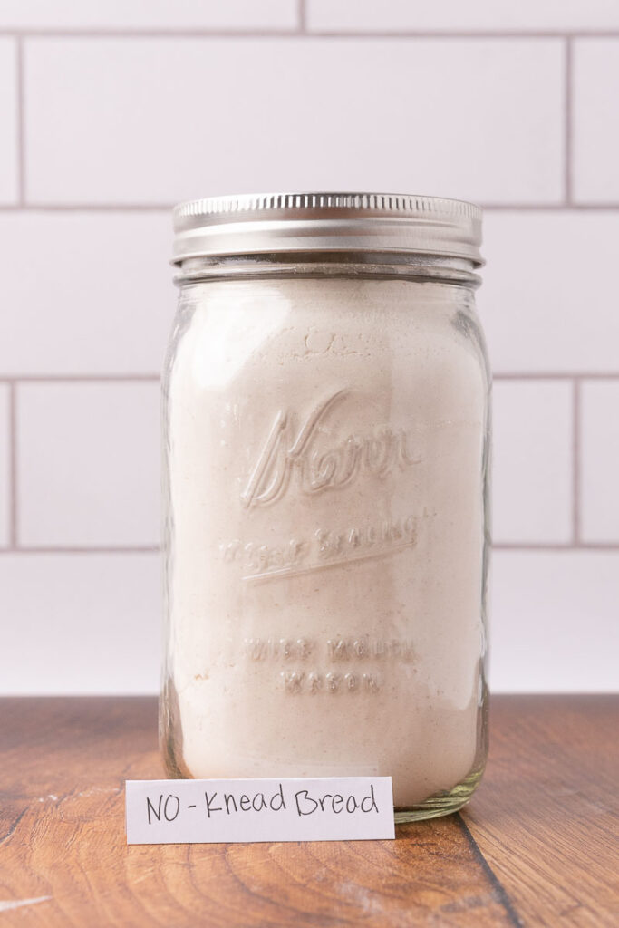 No knead bread ingredients in a Mason jar. 