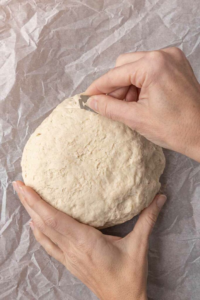 Scoring a loaf of no-knead bread dough.