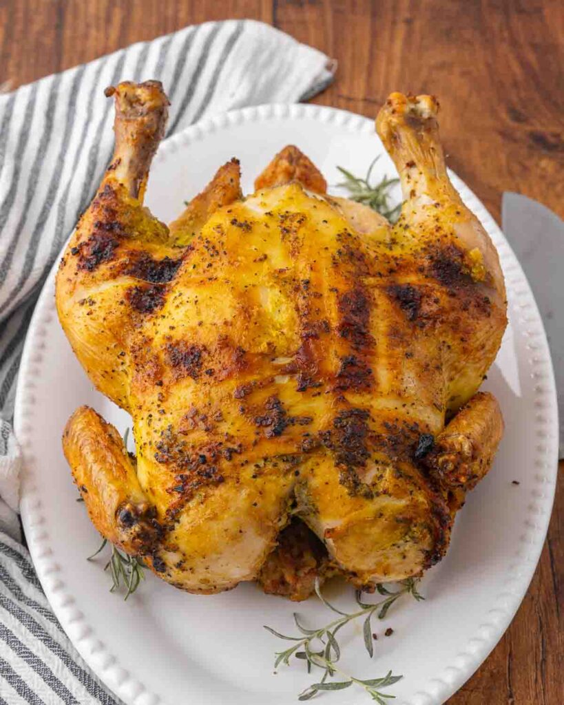 A whole roasted chicken resting on a platter.