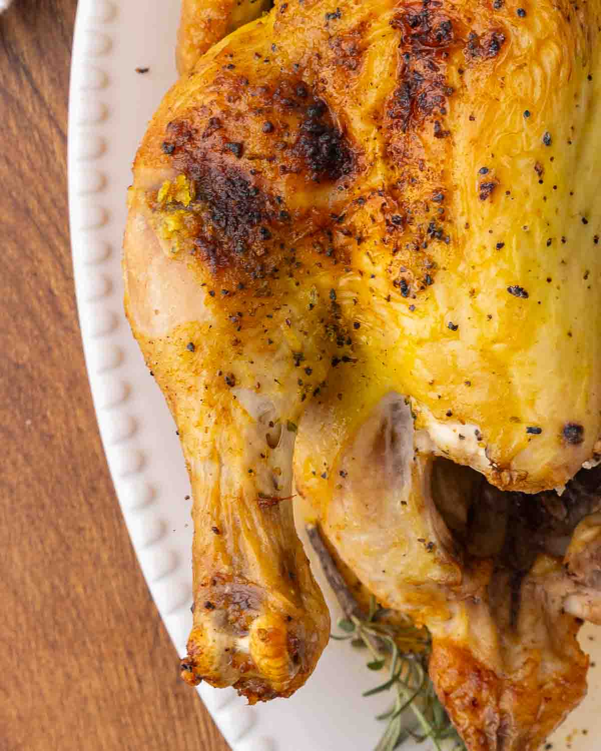 A whole roasted chicken resting on a platter.