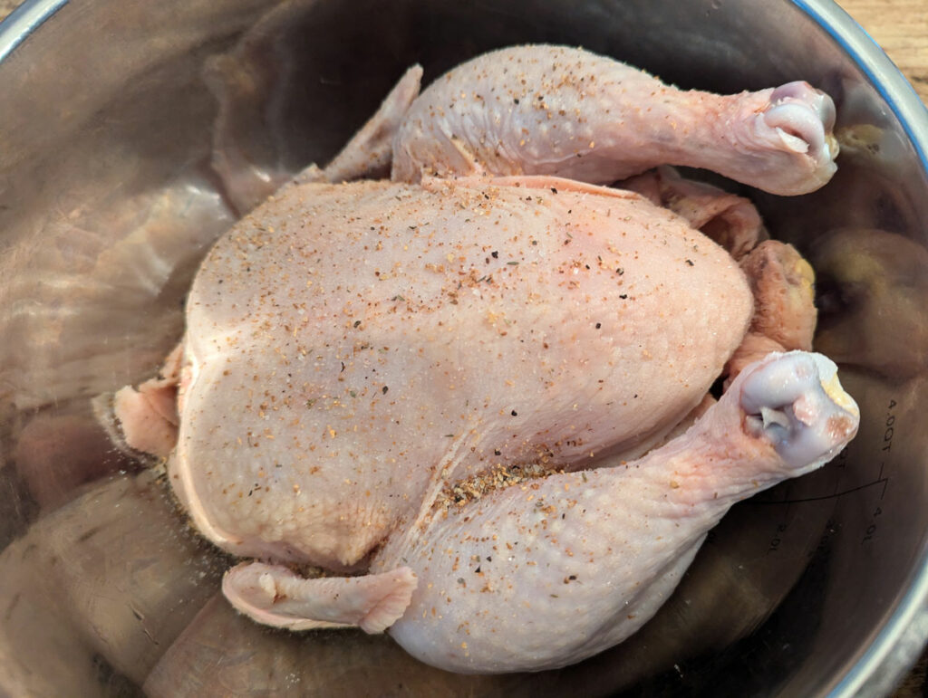 A whole seasoned chicken resting in a bowl.