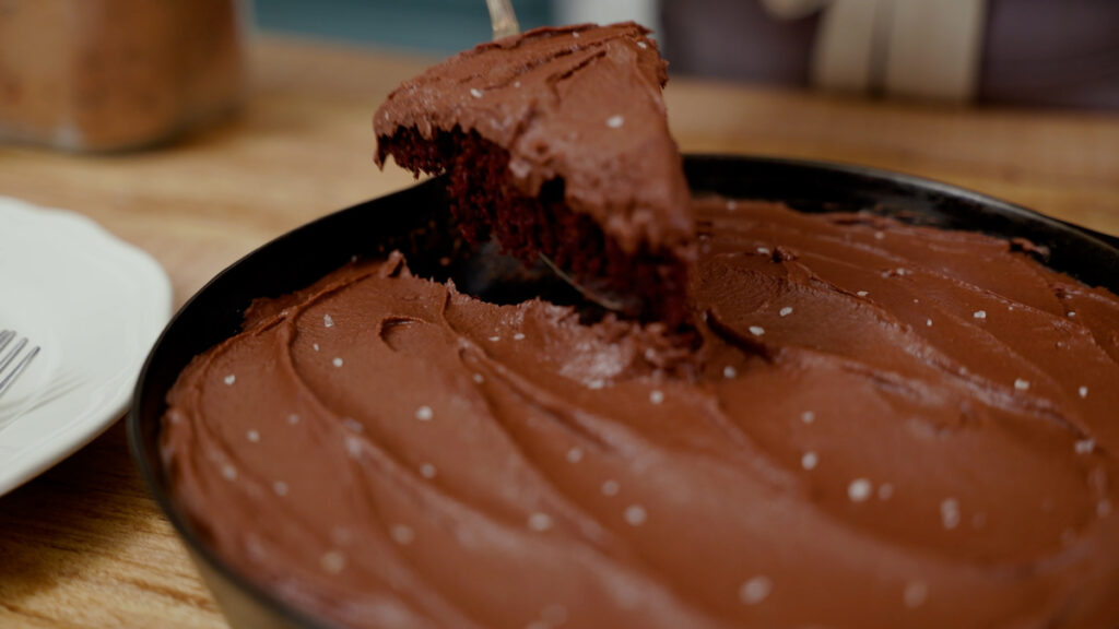 A slice of chocolate wacky cake on a serving utensil.