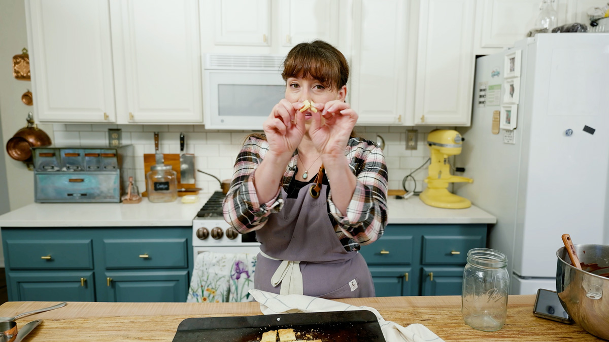 A woman snapping a homemade cracker in half.