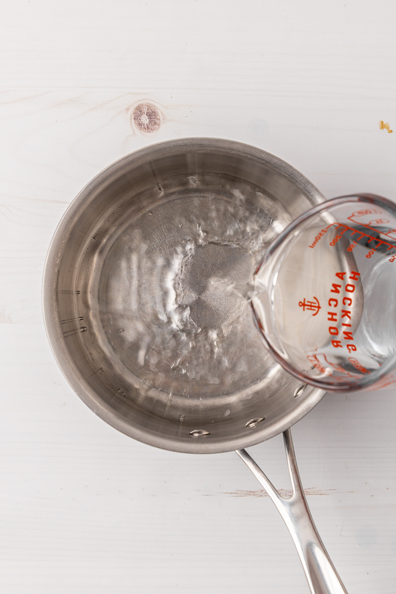 Water being poured into a small saucepan.