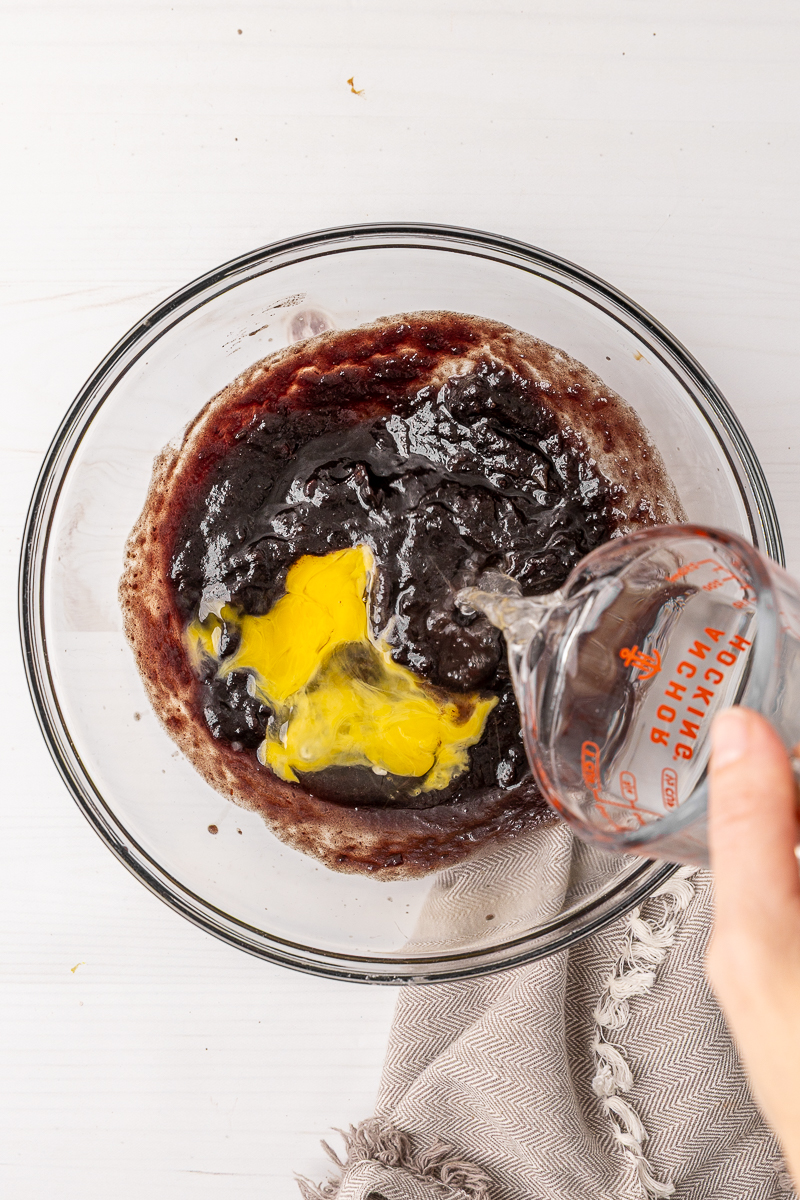 Wet ingredients for this date bread recipe in a clear glass bowl.