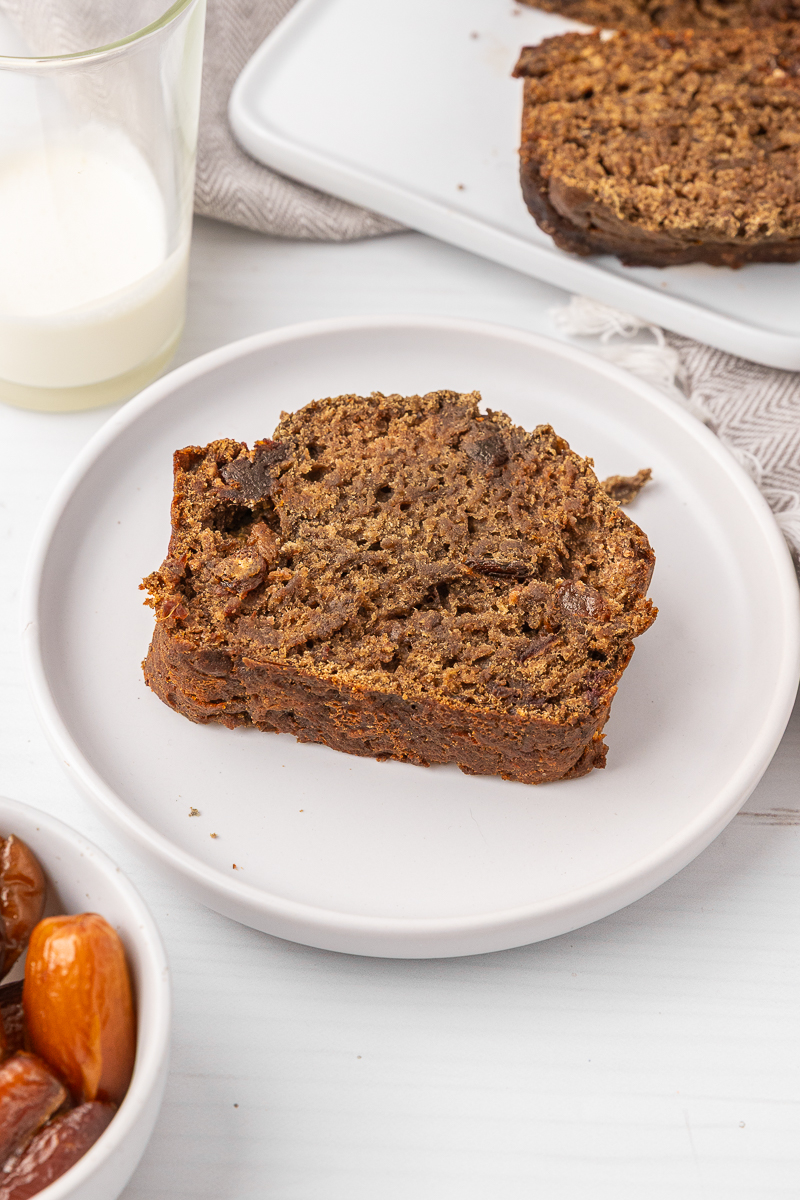 A slice of date bread on a white plate.