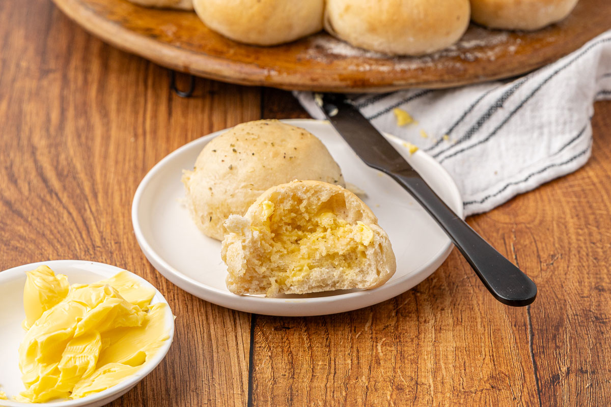 A dinner roll halved with melted butter.