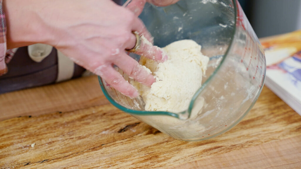 Cracker dough being kneaded in a bowl.