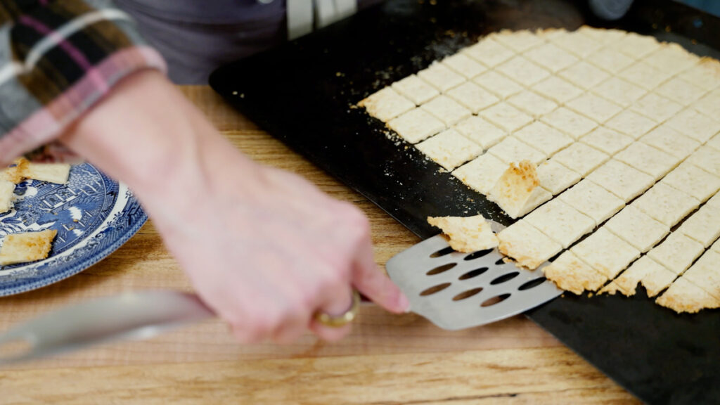 Homemade crackers being removed from the pan with a spatula.