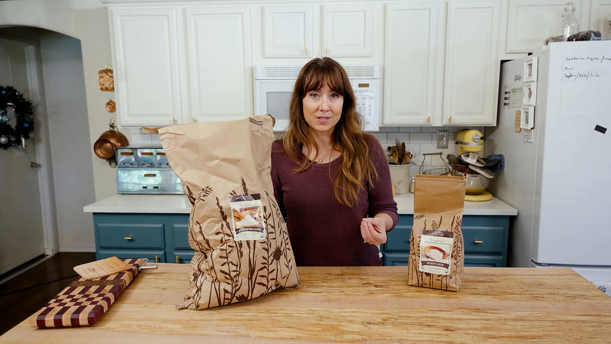 A woman in the kitchen with bulk food bags from Azure Standard.