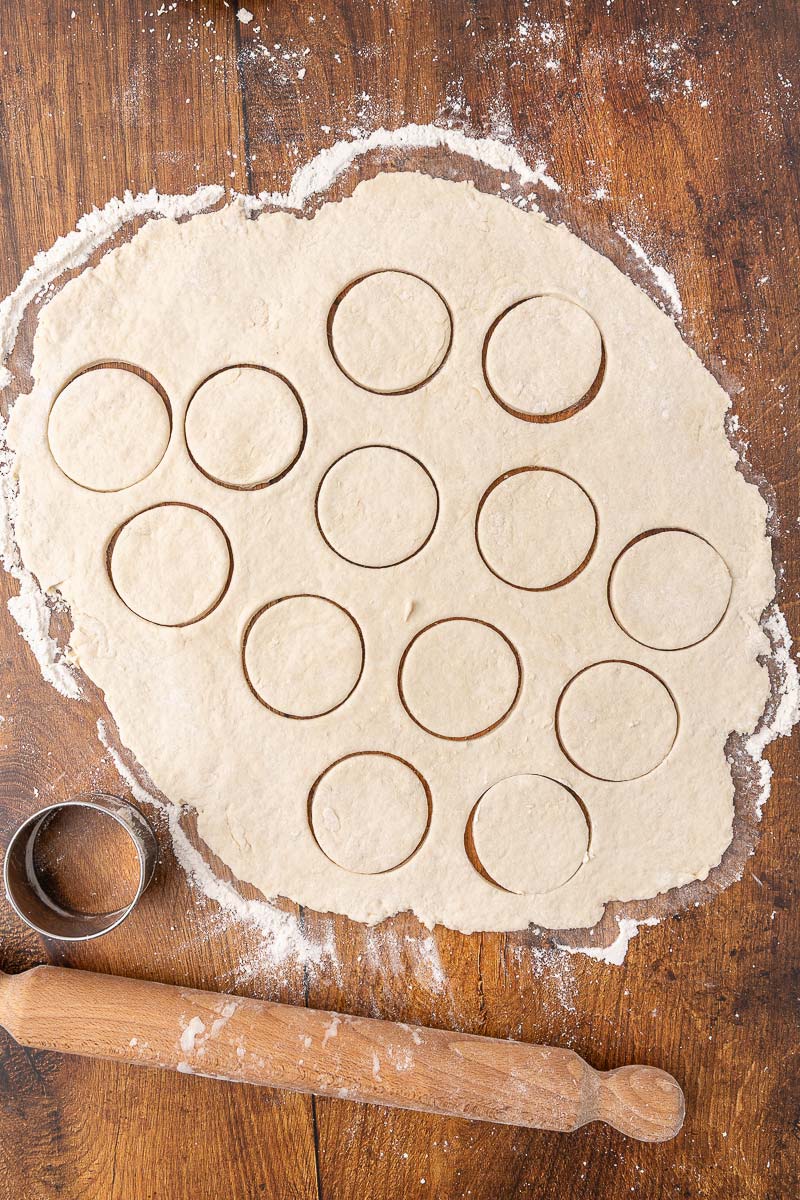 Biscuit dough rolled out and cut with a biscuit cutter.