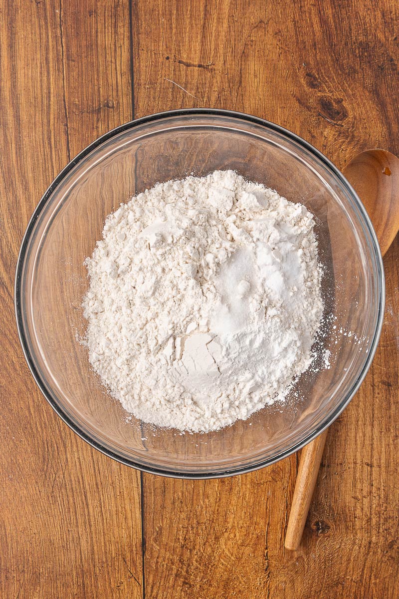 Dry ingredients for homemade biscuits in a glass mixing bowl.