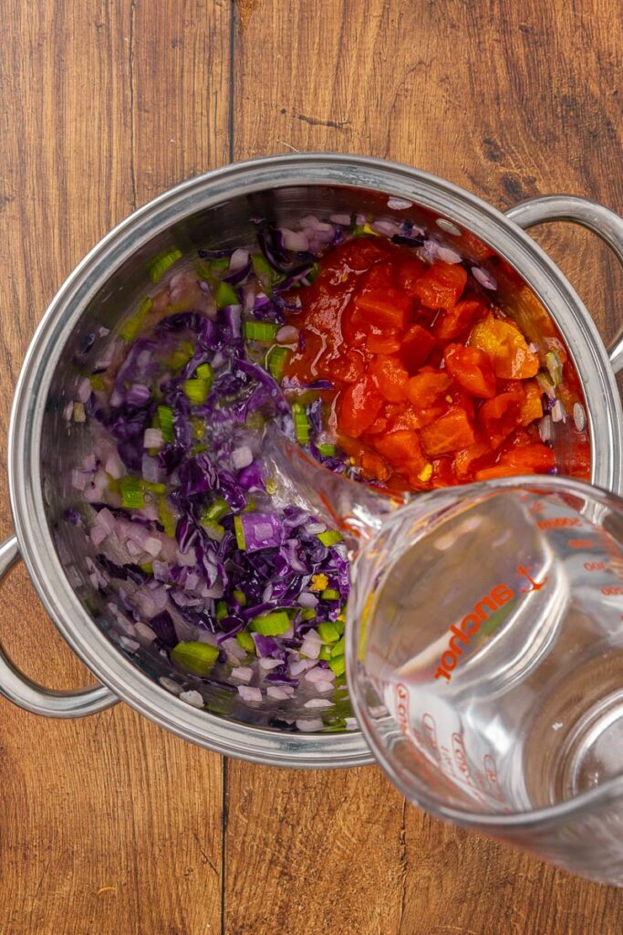 Adding ingredients to a stockpot for traditional Ukranian borscht.