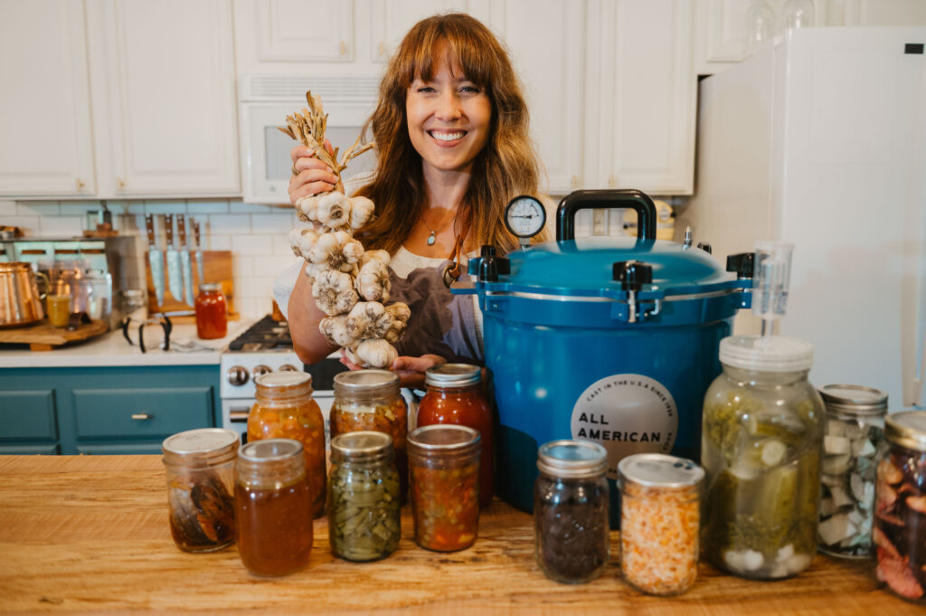 A woman with a counter full of preserved foods.