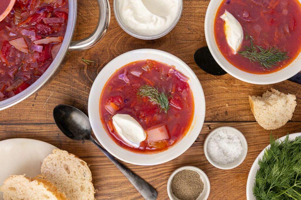 Bird's eye view of traditional Ukranian borscht served in bowls and garnished with sour cream.