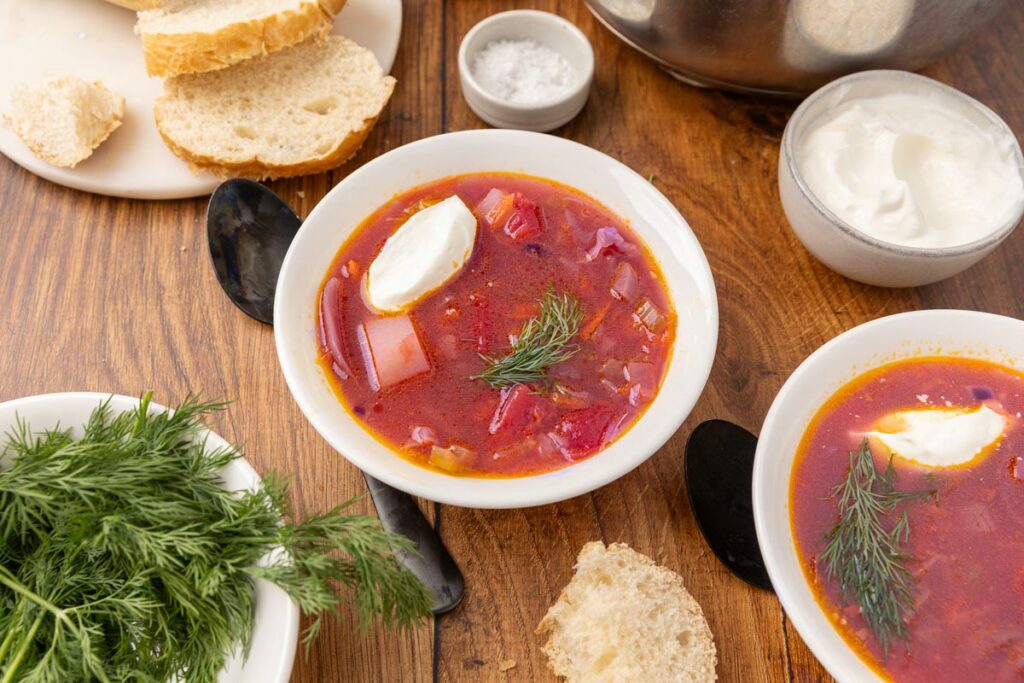 Bowl of traditional Ukranian borscht with slices of bread.