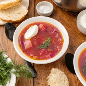 Bowl of traditional Ukranian borscht with slices of bread.