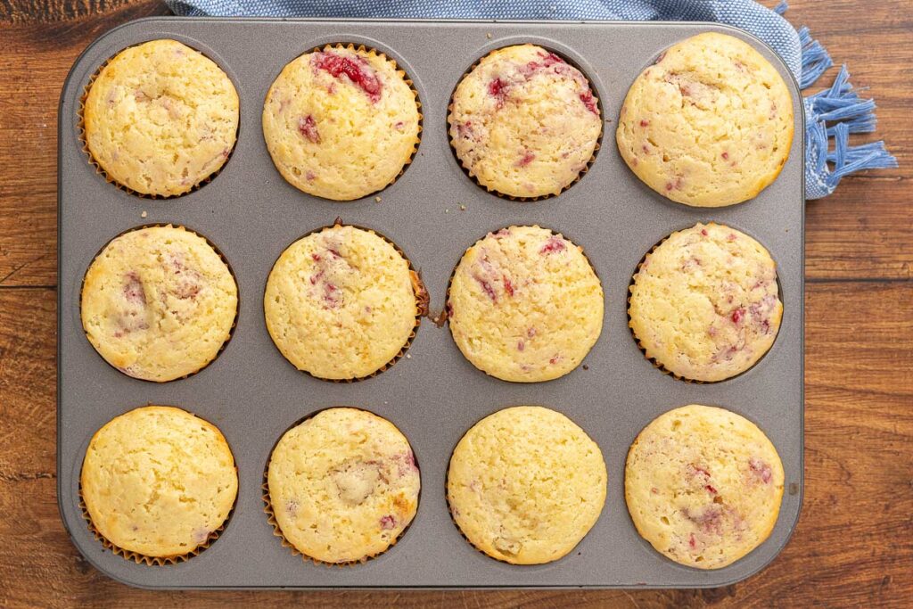 Baked raspberry cream cheese muffins in a muffin tin.