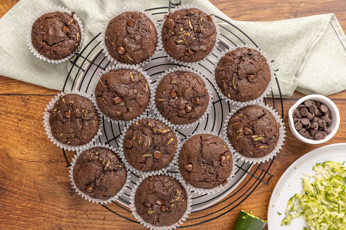 Double chocolate zucchini muffins cooling on a rack.