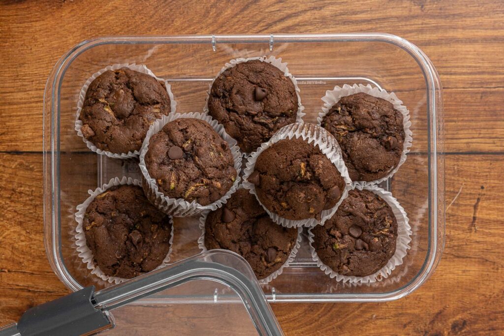 Double chocolate zucchini muffins in an airtight container ready for storage.