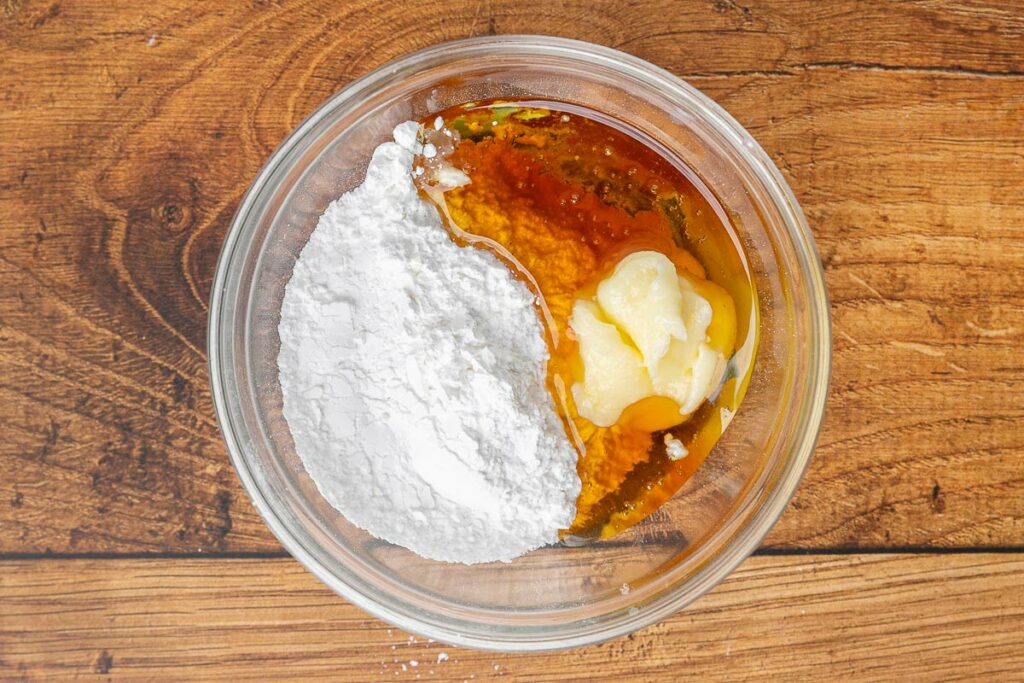 Maple glaze ingredients in a bowls: powdered sugar, maple syrup, and buttter.
