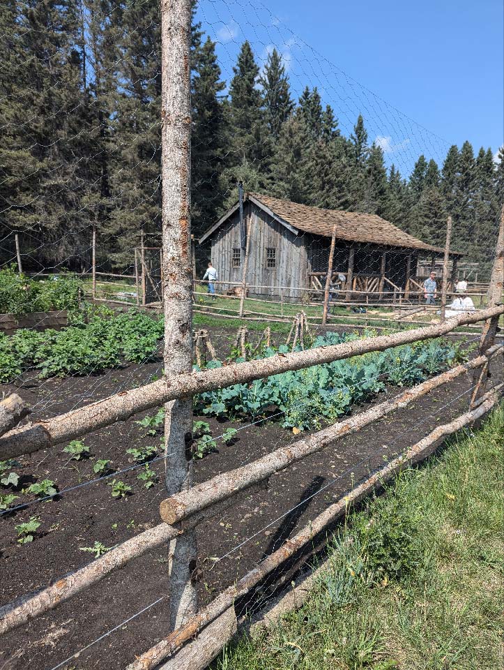 A old farmhouse with a garden in the foreground.