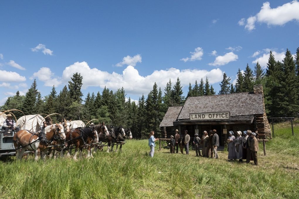 People standing in front of an 1800s Land Office.