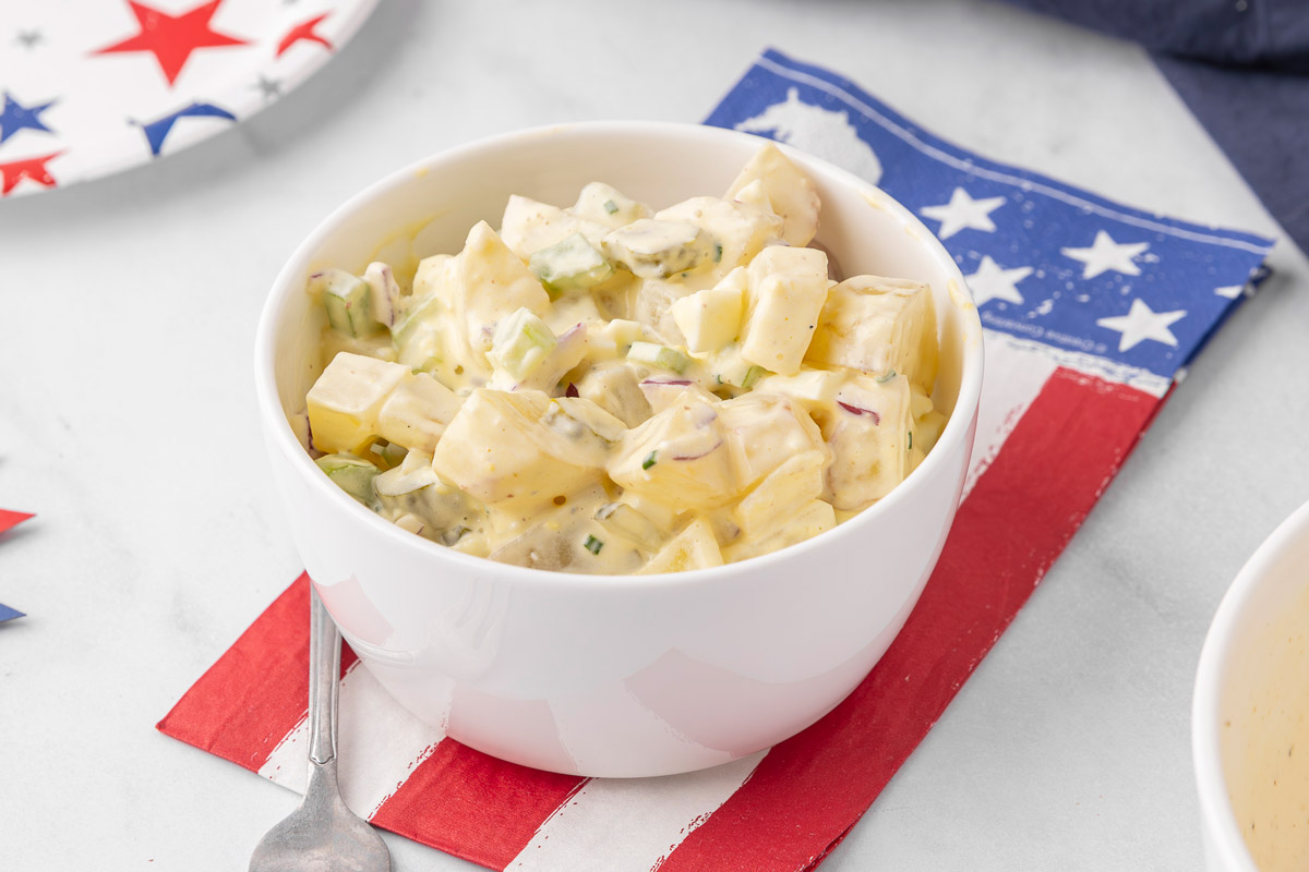 A white bowl filled with potato salad.