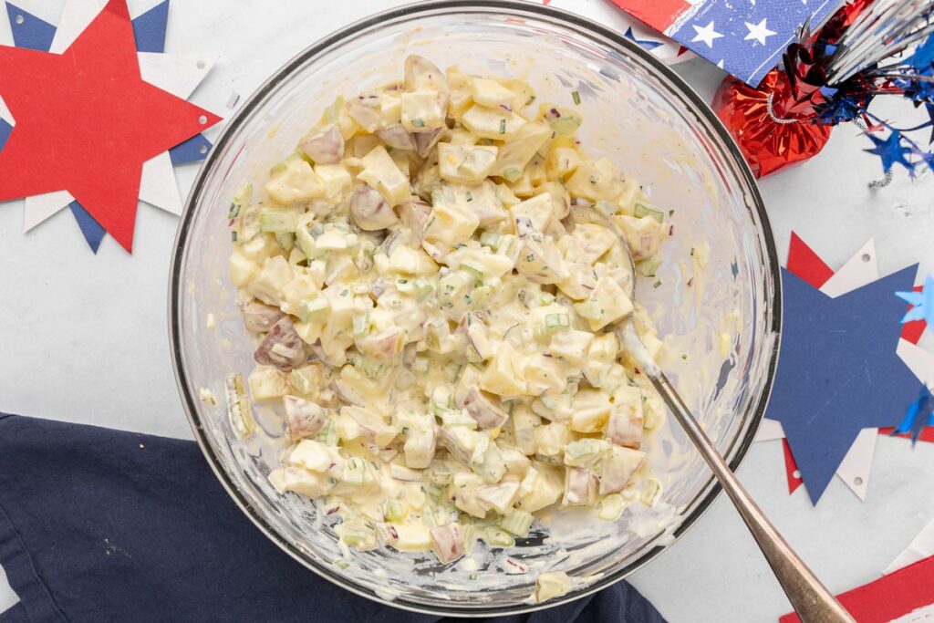 A serving bowl filled with creamy potato salad.