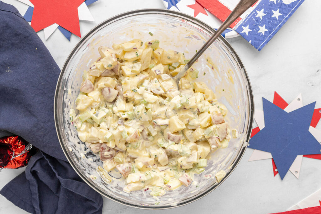 A serving bowl filled with creamy potato salad.
