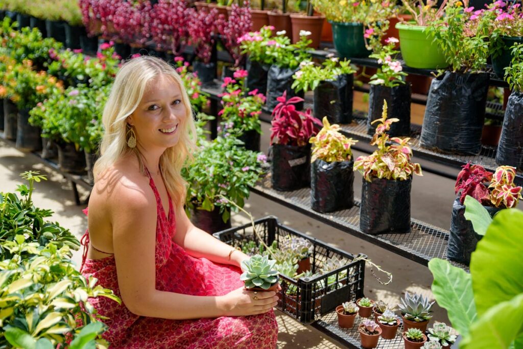 A woman sitting in a garden center.
