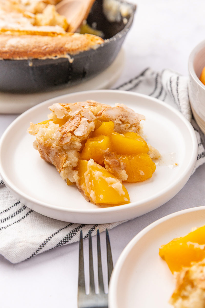 Peach cobbler served on a white plate.