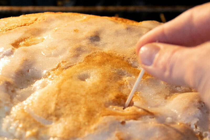 A toothpick testing the doneness of peach cobbler.