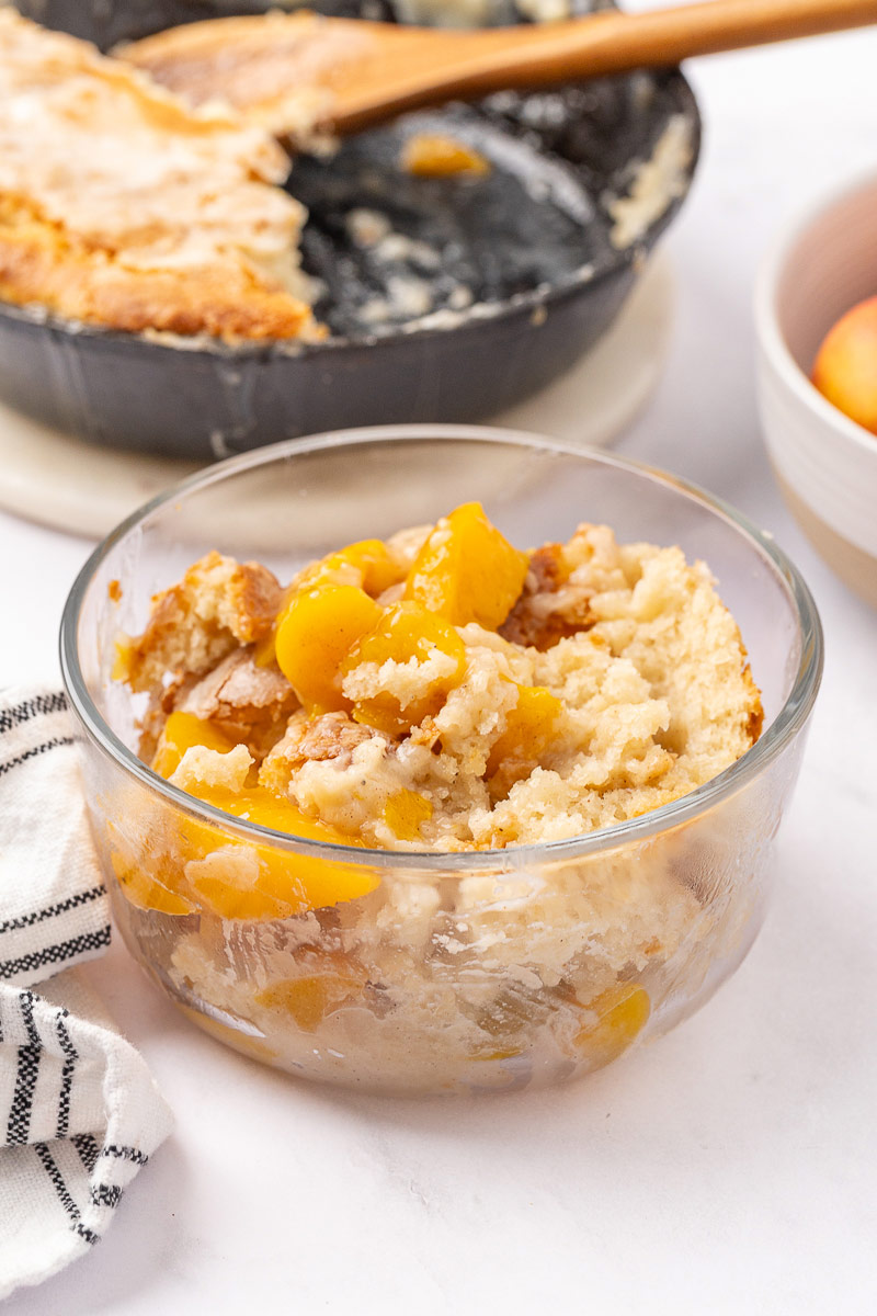Peach cobbler in a glass Tupperware container.