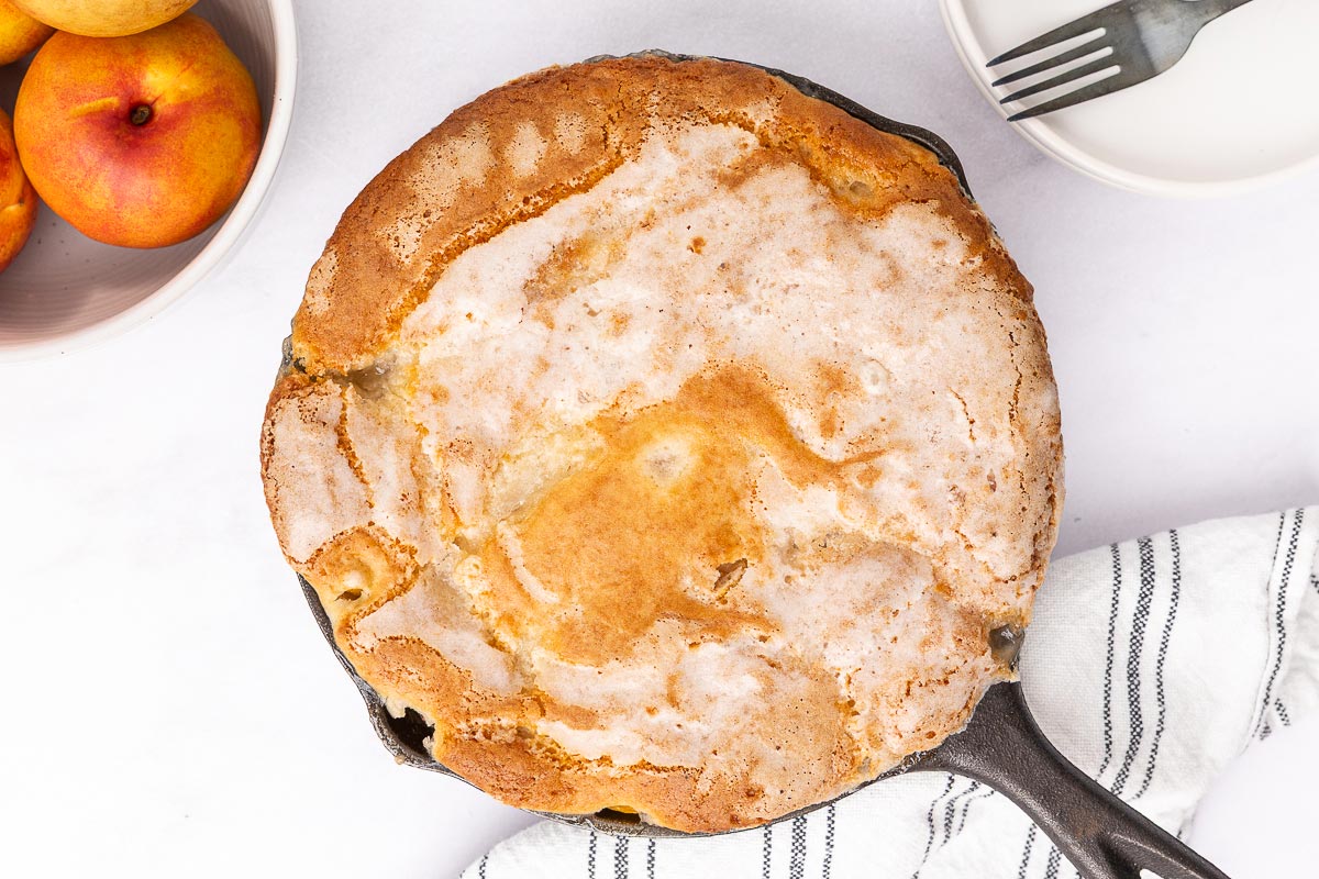 Peach cobbler in a cast iron pan.