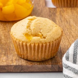 Peach muffin on a cutting board.