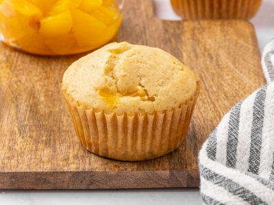 Peach muffin on a cutting board.