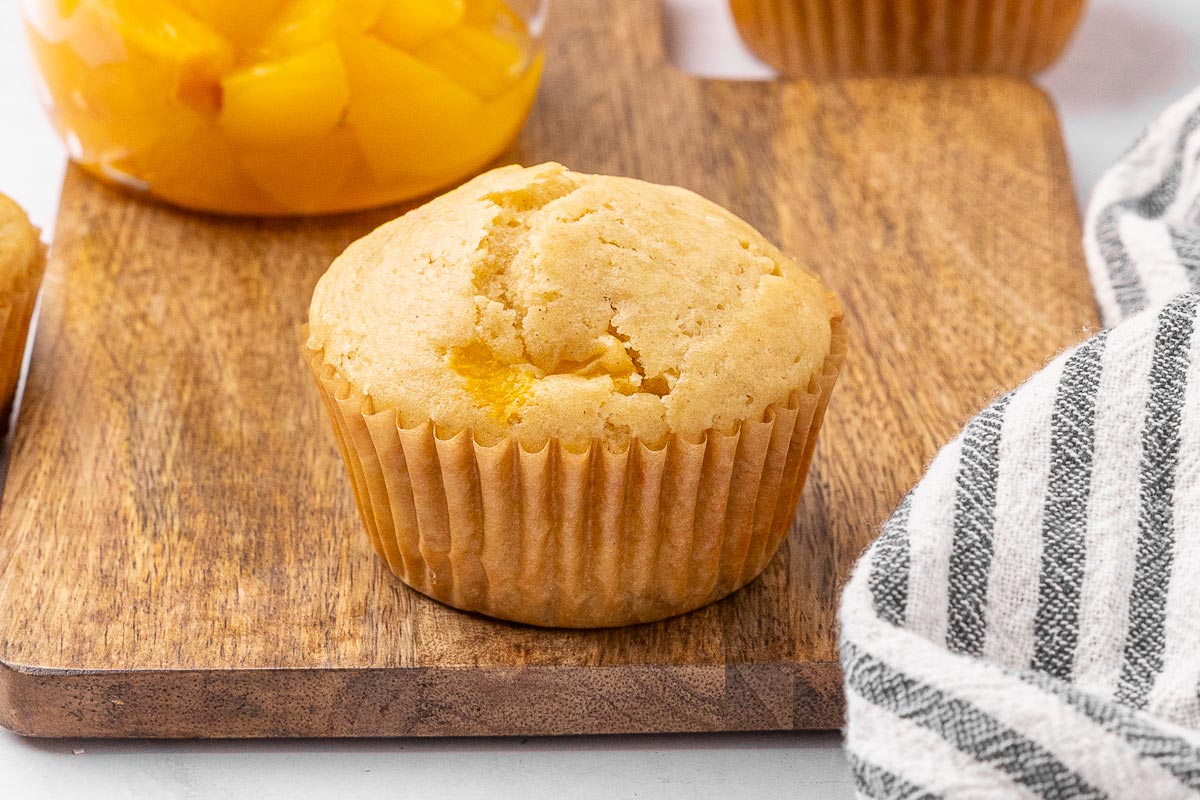 Peach muffin on a cutting board.