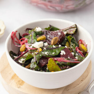 Roasted beet salad with goat cheese in a white serving bowl.