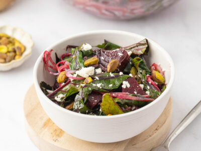 Roasted beet salad with goat cheese in a white serving bowl.