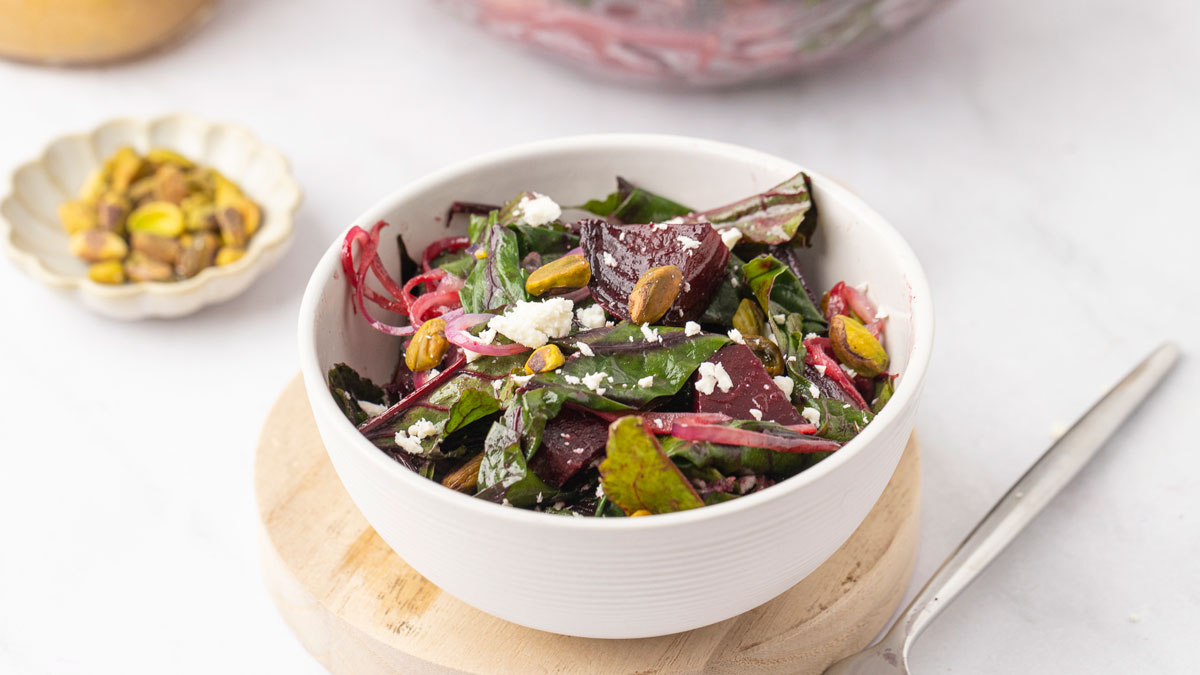 Roasted beet salad with goat cheese in a white serving bowl.