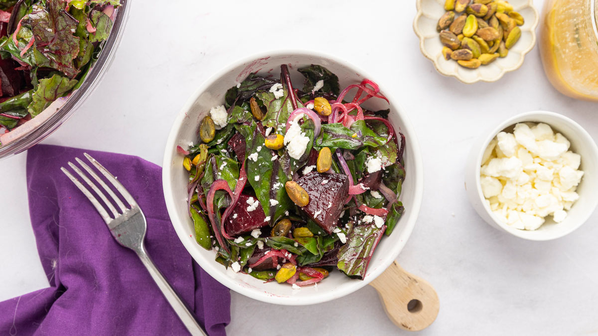 Roasted beet salad with goat cheese in a white serving bowl.